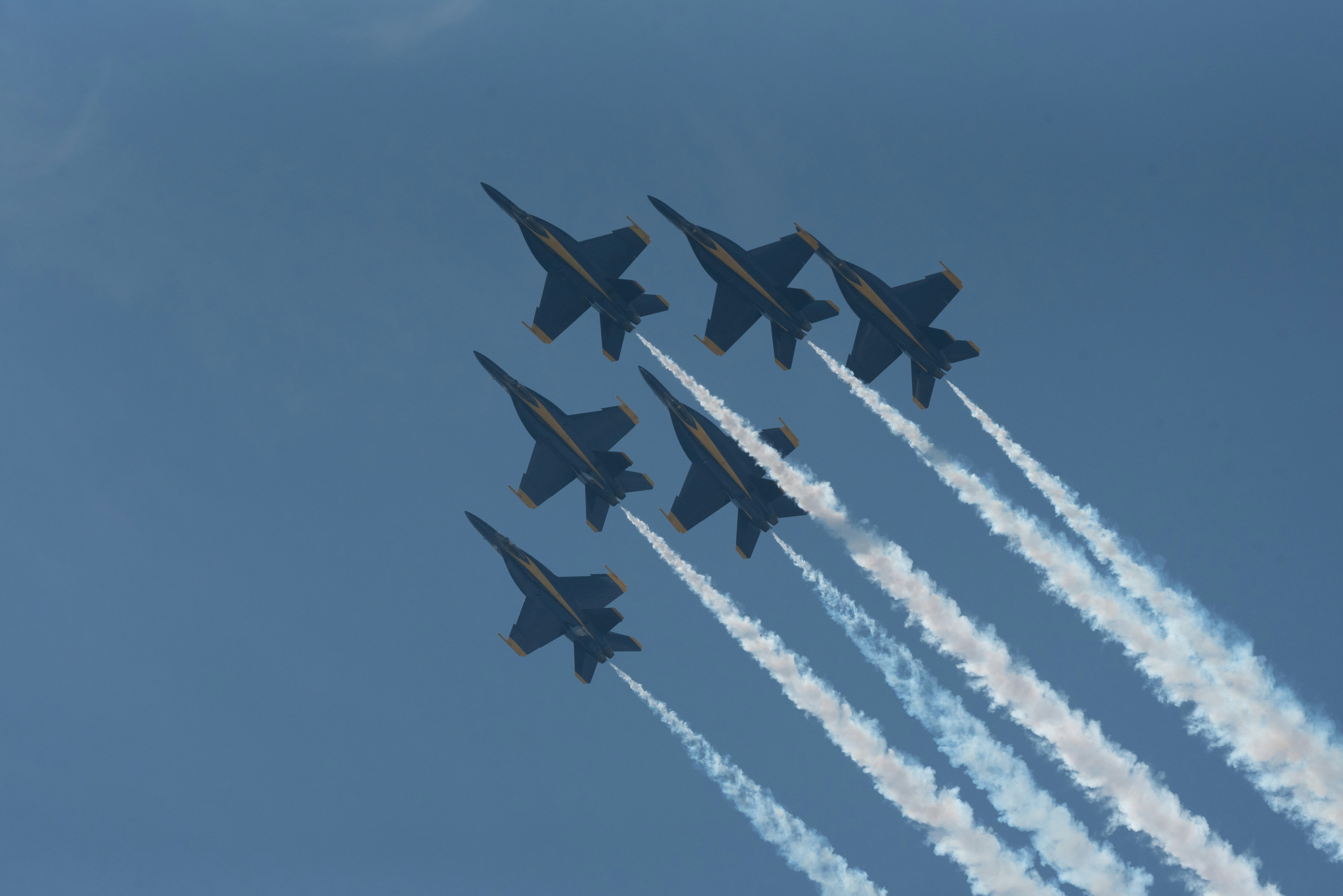 a group of fighter jets flying through a blue sky, 