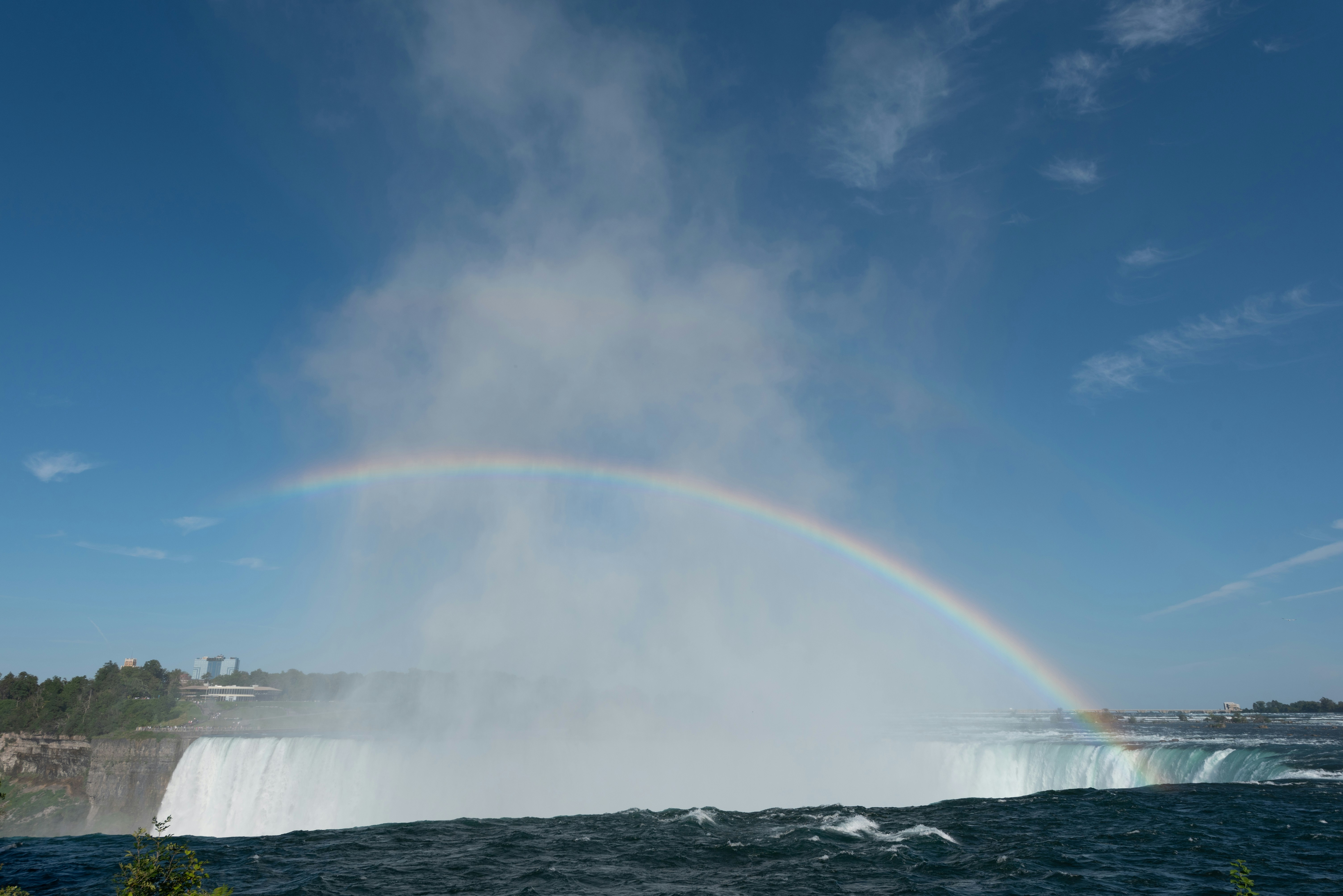 a rainbow in the sky over a waterfall