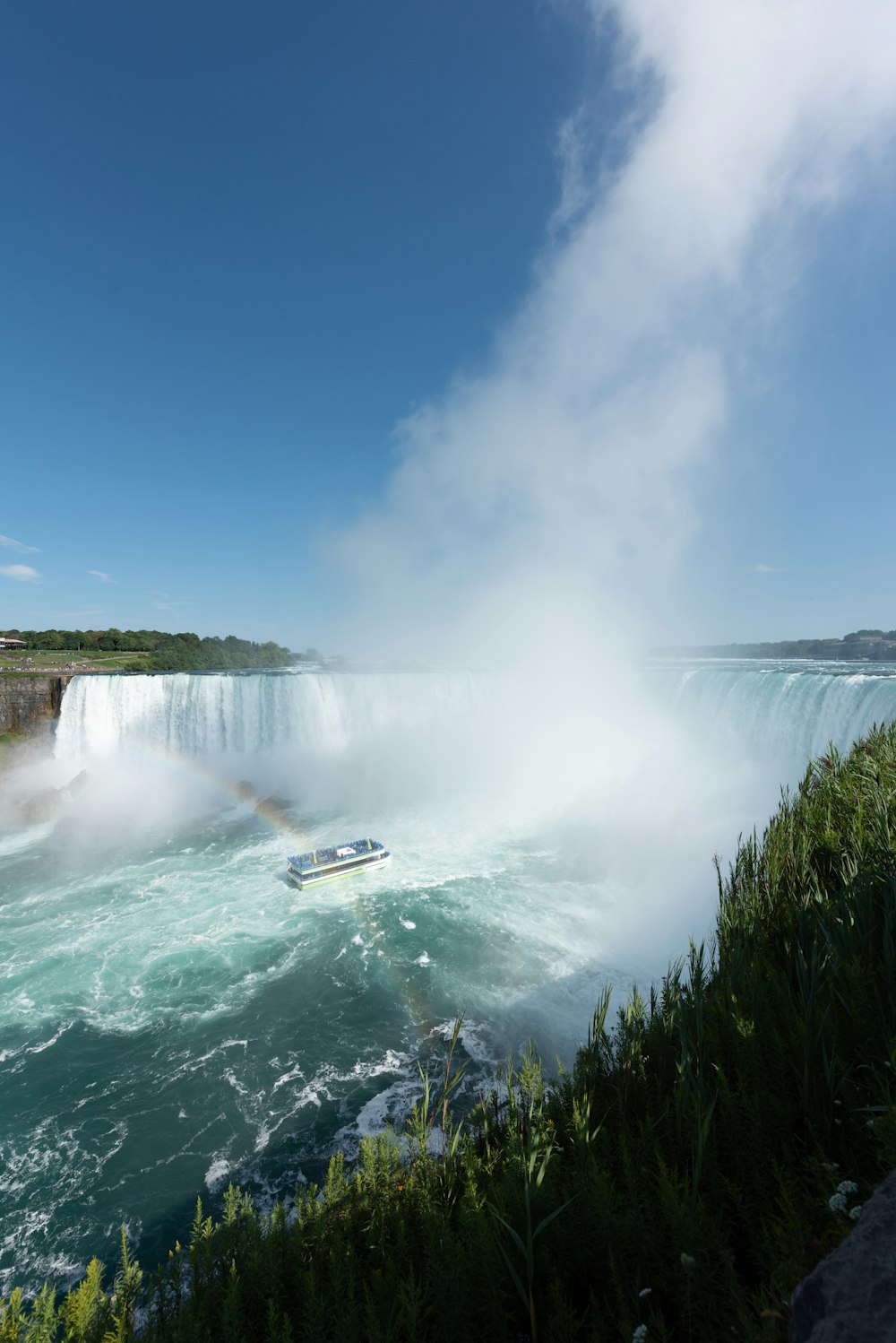 a boat is in the water near a waterfall