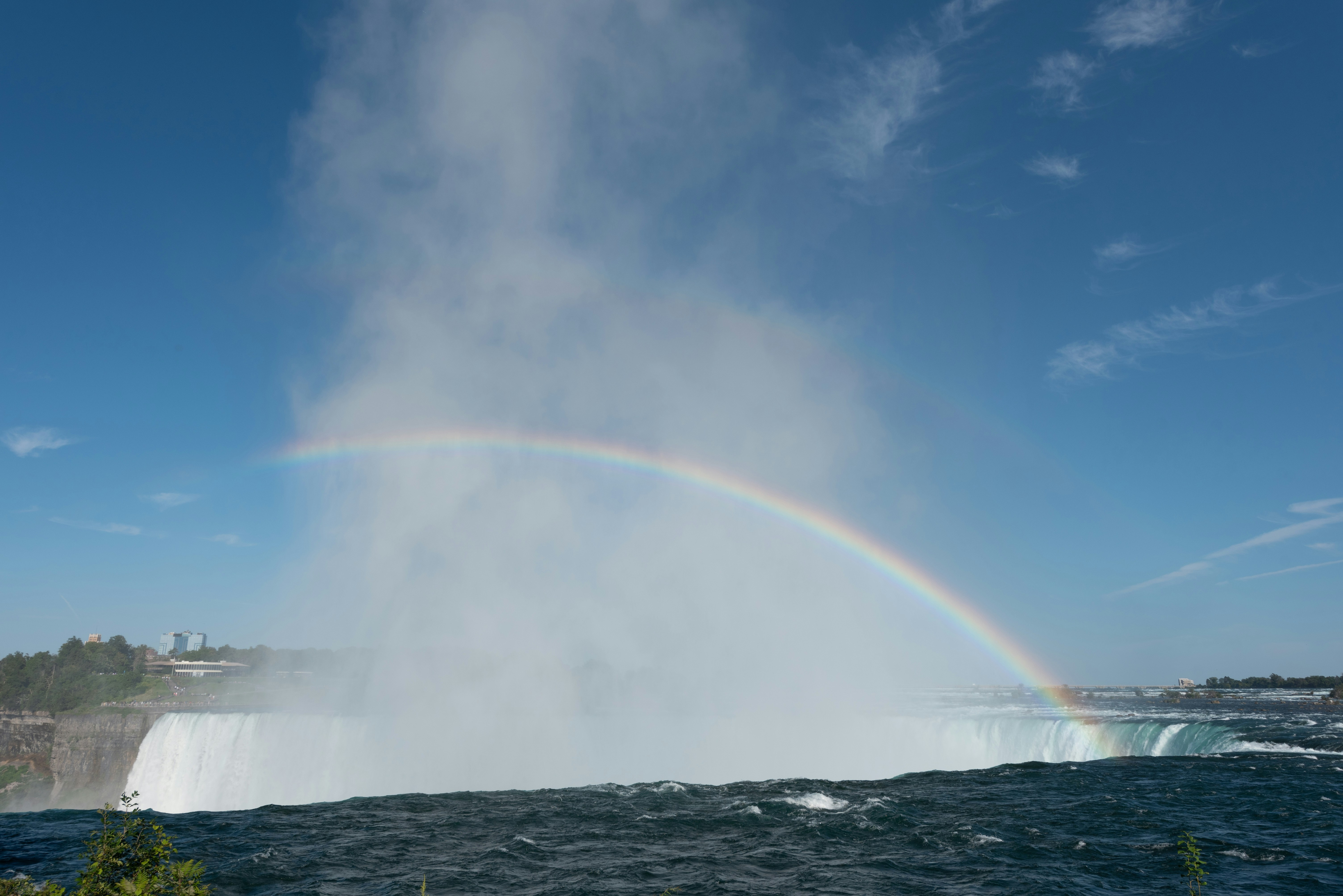 a rainbow in the sky over a waterfall