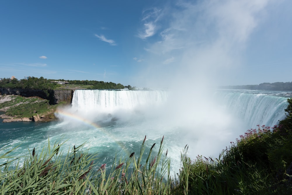 a large waterfall with a rainbow in the middle of it