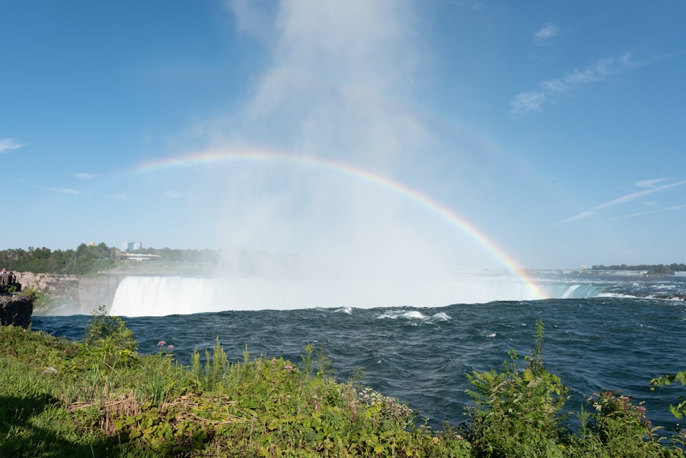 a rainbow in the sky over a waterfall