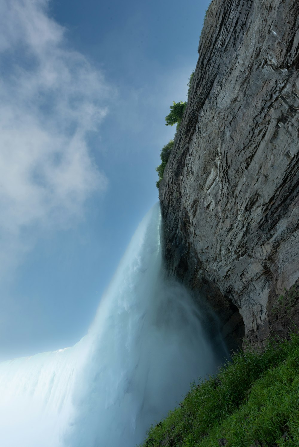 a large waterfall is coming out of the side of a cliff