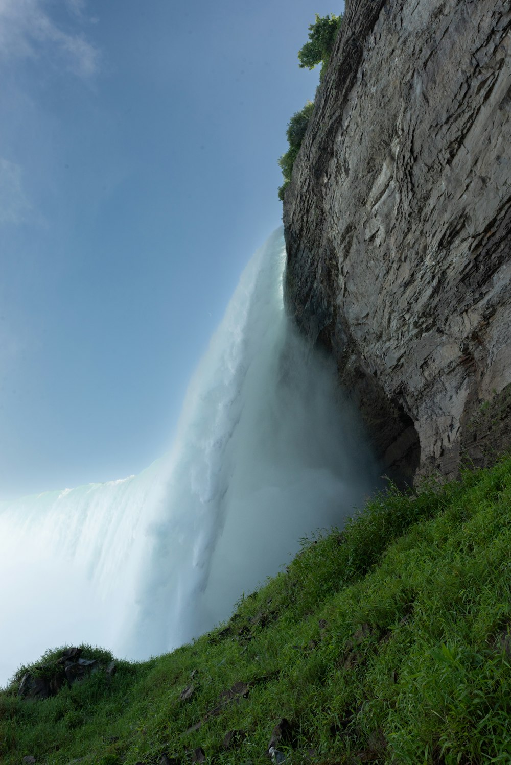 a large waterfall is coming out of the side of a cliff