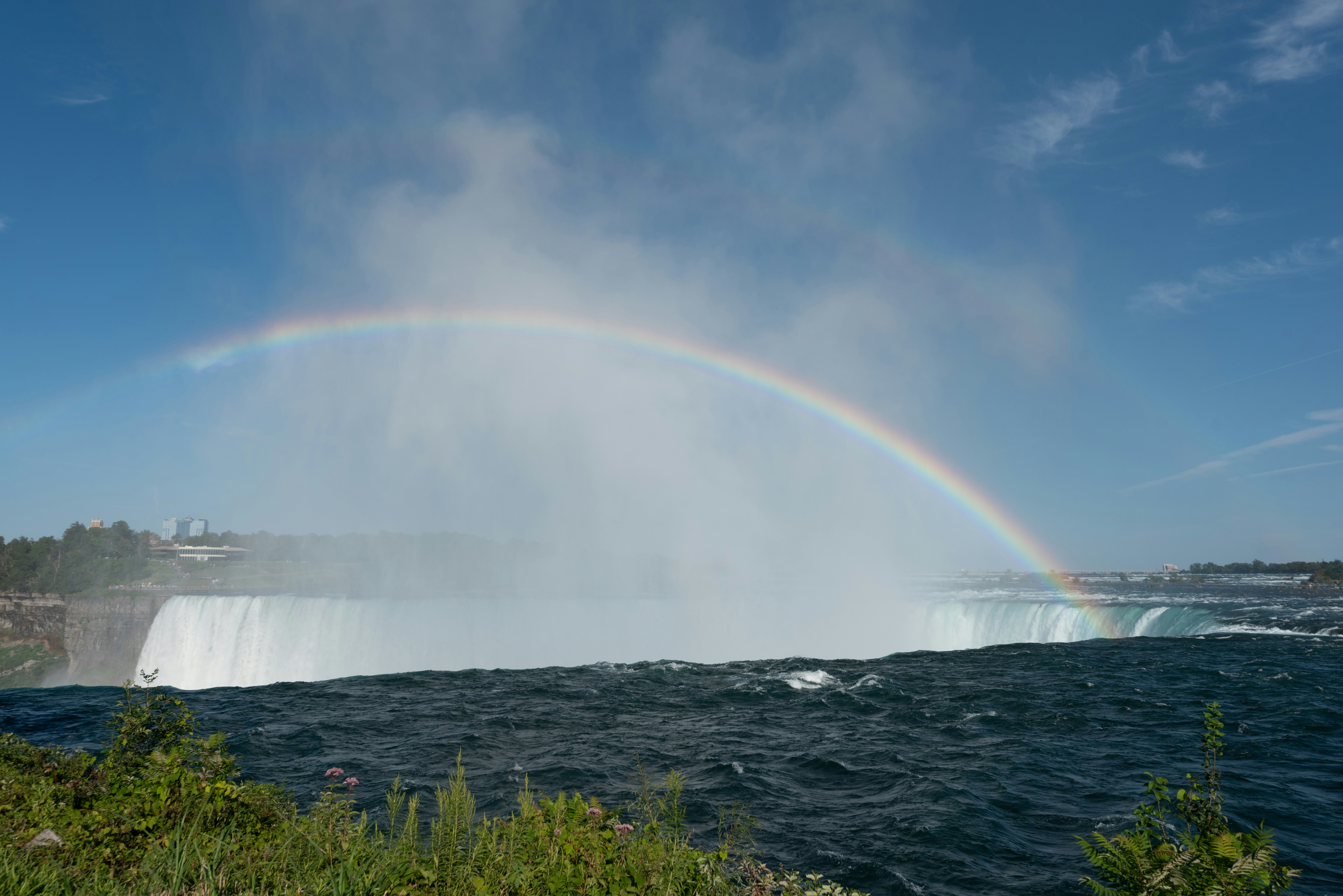 a rainbow in the sky over a waterfall