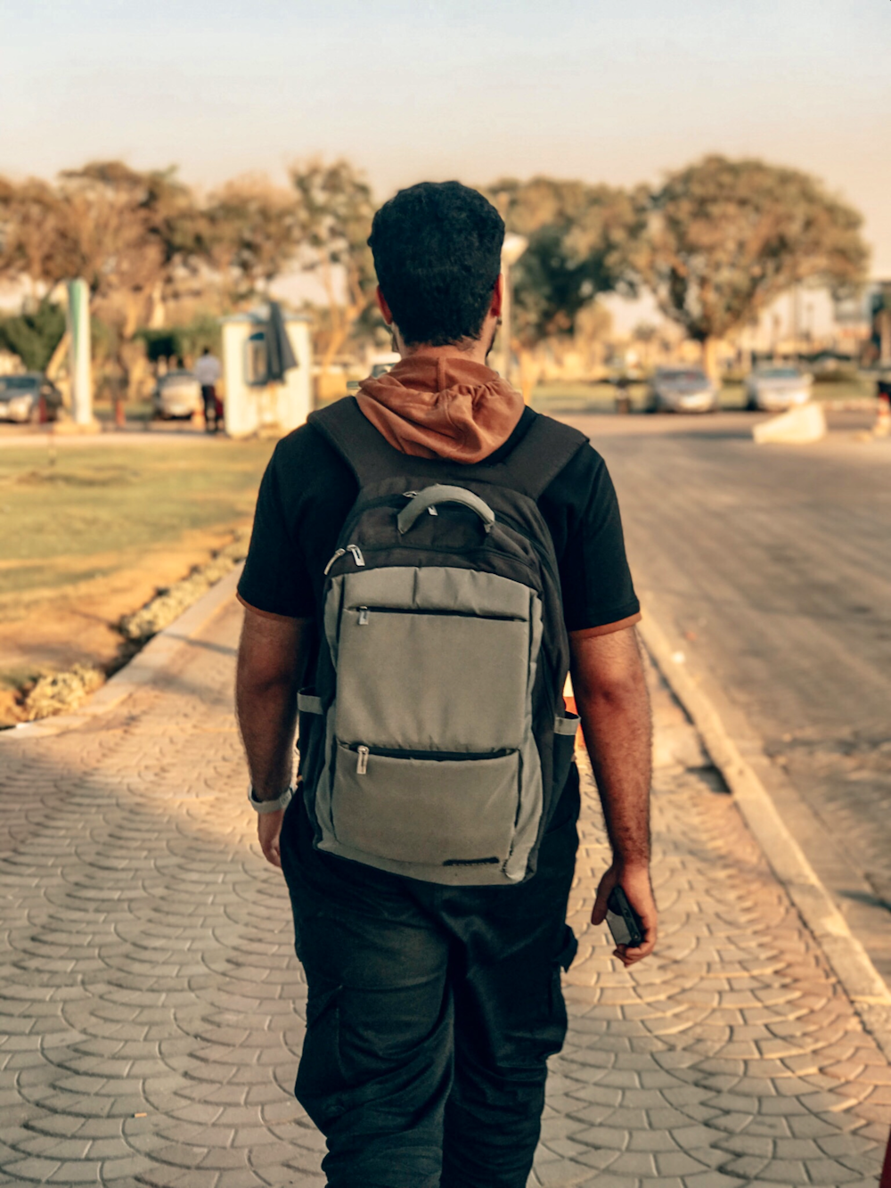 a man with a backpack walking down a street