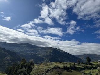 A scenic view of the Zimbabwean countryside with rolling hills and green fields.