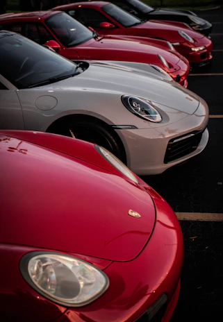A lineup of imported cars with black, gold, and silver accents under soft lighting.