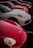 A lineup of luxury sports cars parked in a row, predominantly featuring sleek red and white models. The cars are positioned diagonally, showcasing their aerodynamic designs and shiny exteriors, highlighted by the soft ambient light.