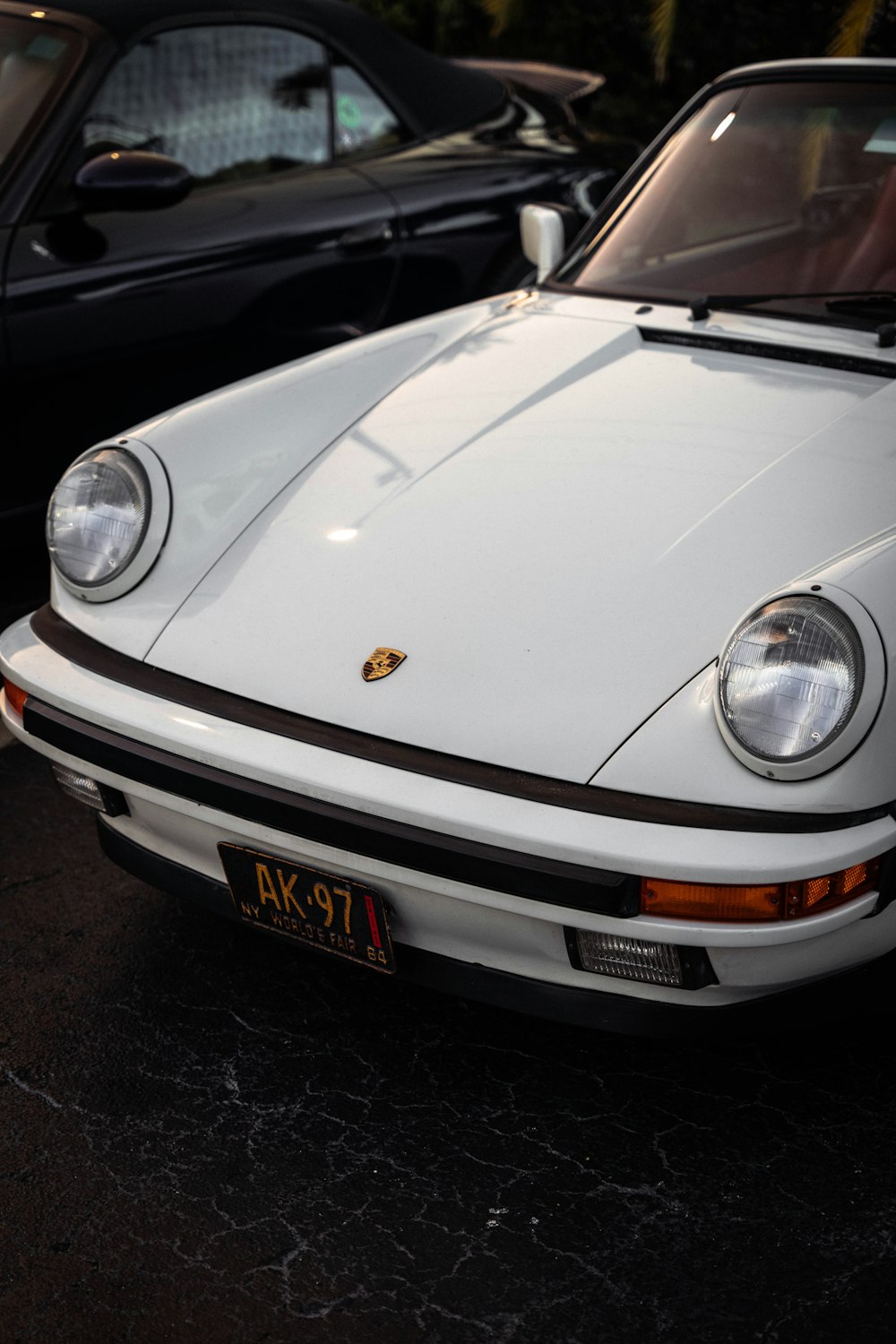 a white porsche parked in a parking lot