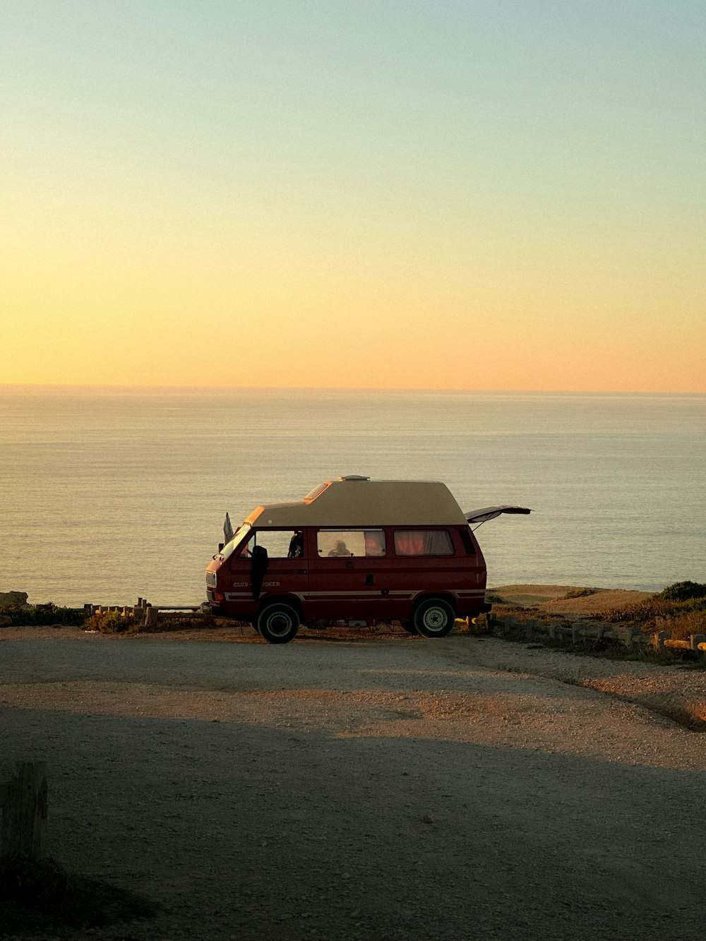 a van parked on the side of a road next to the ocean
