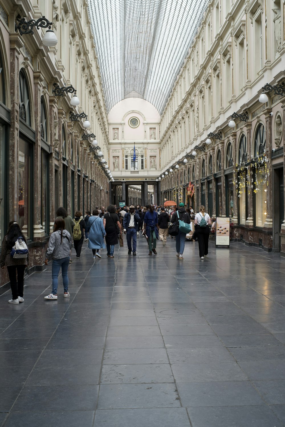 a group of people walking down a long hallway