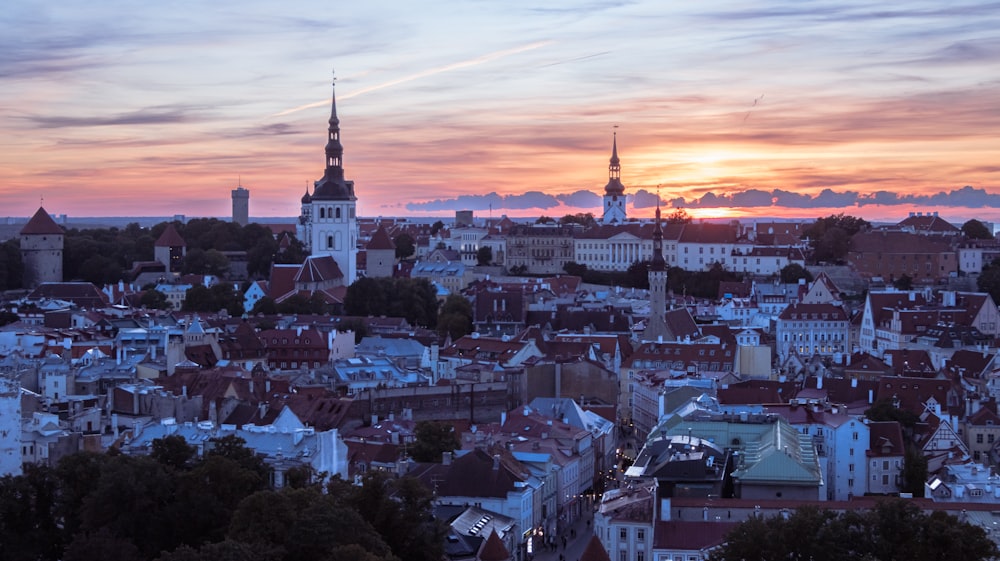 uma vista de uma cidade ao pôr do sol de uma colina