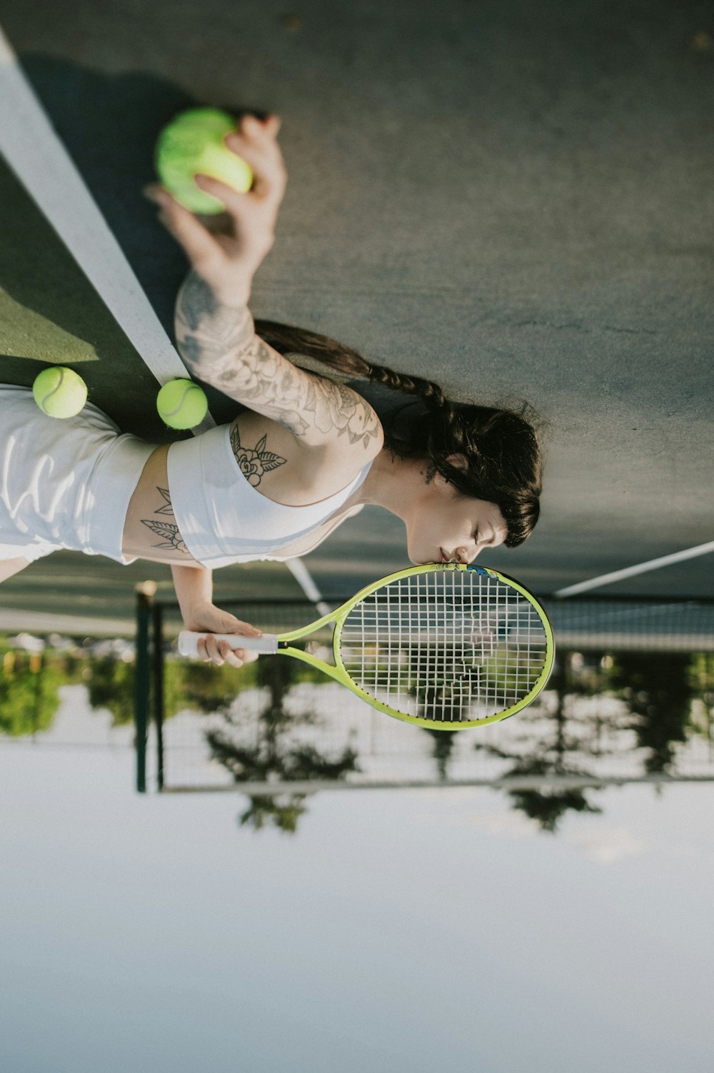 a woman holding a tennis racquet and tennis balls