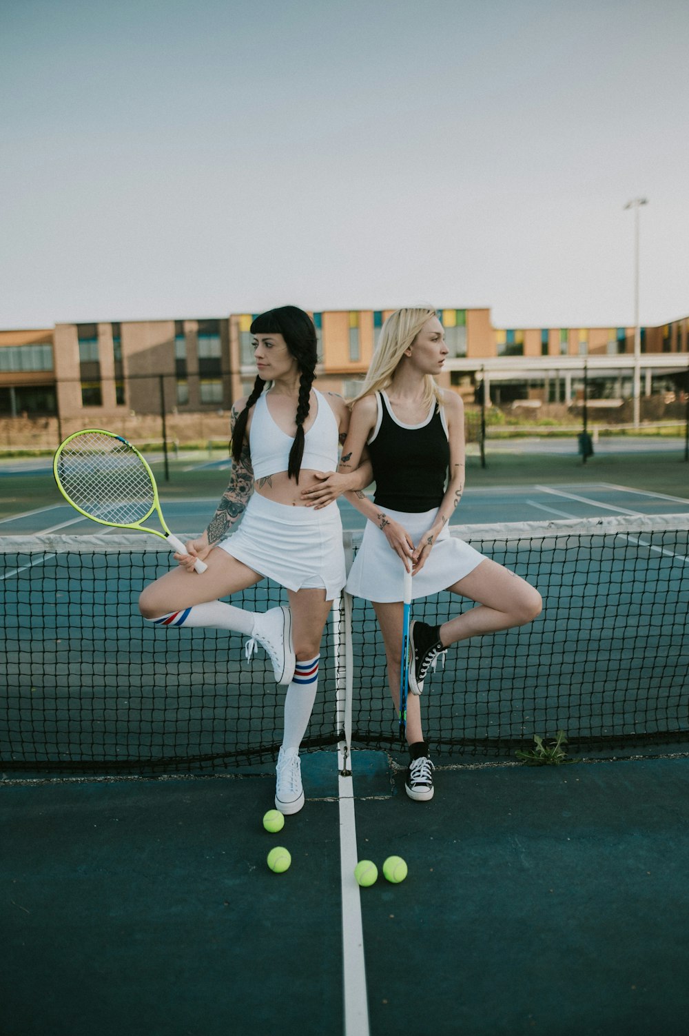 two women standing on a tennis court holding racquets