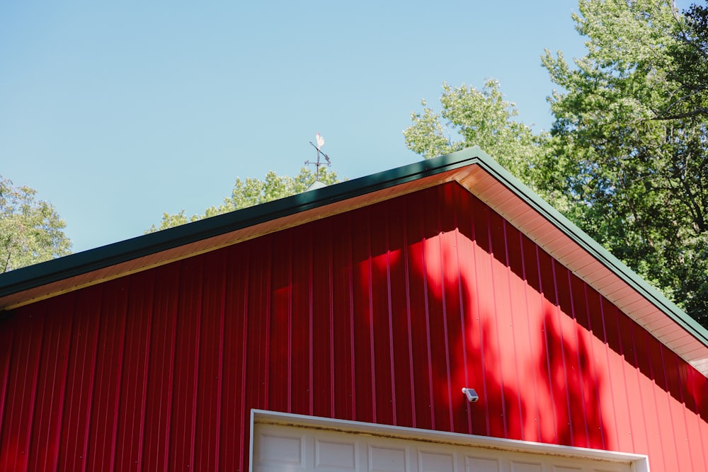 a red building with a green roof and a white door