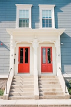a couple of red doors sitting on the side of a building