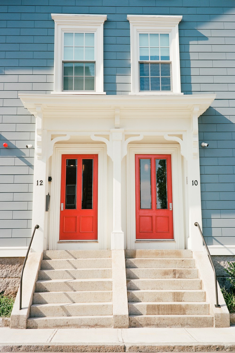 a couple of red doors sitting on the side of a building