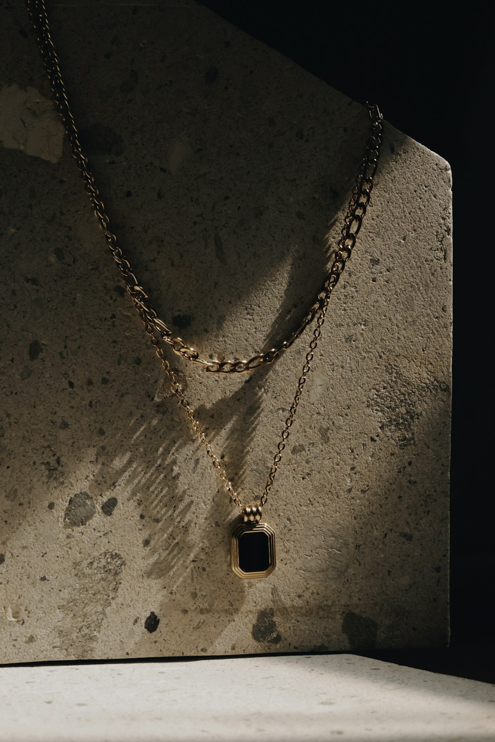 a necklace with a black stone hanging from it