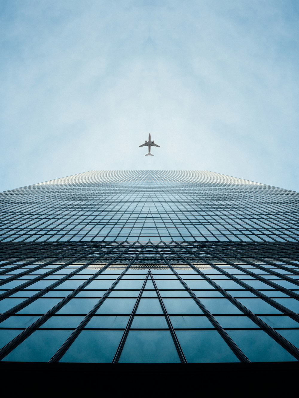 an airplane flying in the sky over a tall building