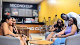Community members chatting and laughing in a cozy coffee shop setting.