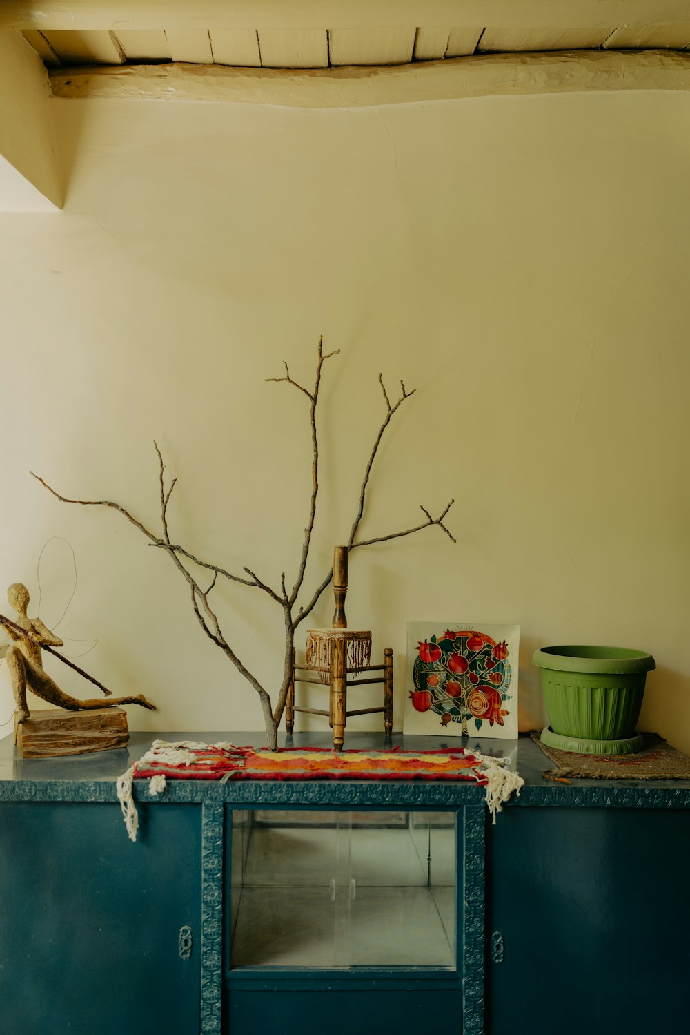 a blue cabinet with a tree branch on top of it