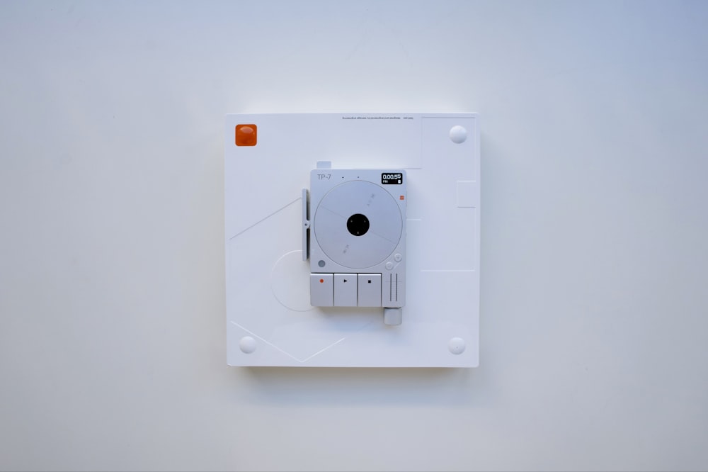 a white wall mounted electrical device on a white wall