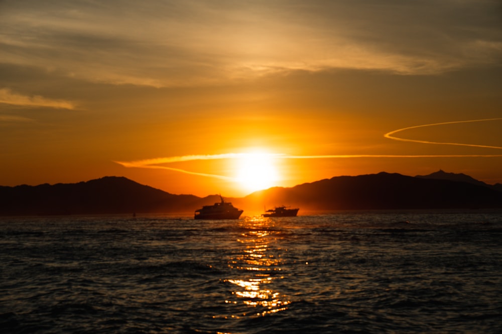 遠くにボートがある水域に沈む夕日