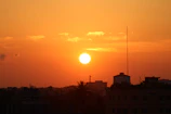 Sunset over Monterrey's city skyline with warm orange hues.