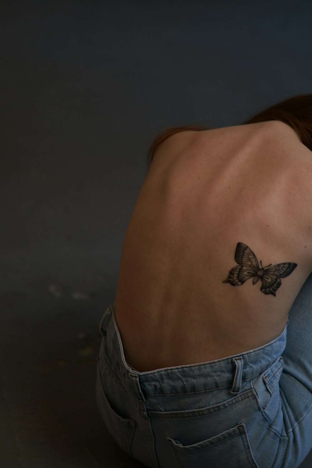 a woman with a butterfly tattoo on her back