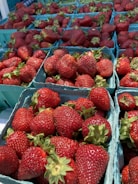 Fresh strawberries and blueberries in a woven basket on a kitchen counter.