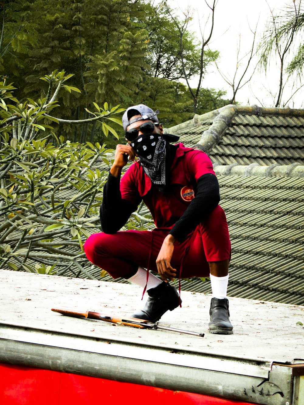 a man in a red shirt and a black mask