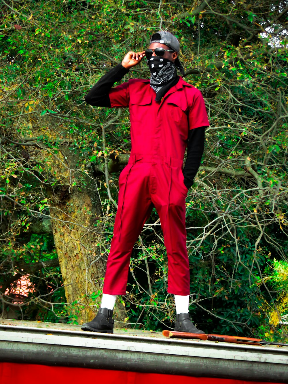 黒いマスクをかぶった赤いジャンプスーツを着た男