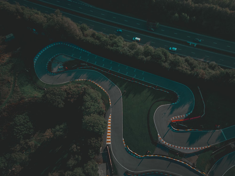 an aerial view of a winding road in the middle of a forest