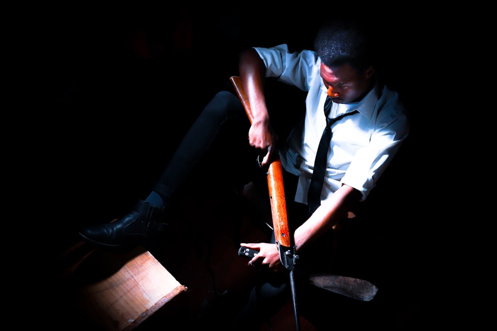 a man sitting on a chair holding a pair of scissors