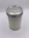 A glass jar with a metal lid, filled with a white substance, sits on a light background. The jar has a textured design that gives it an intricate appearance.