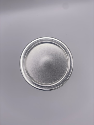 Frosted glass container with a sharp metallic silver rim showcasing a memecoin project cover.