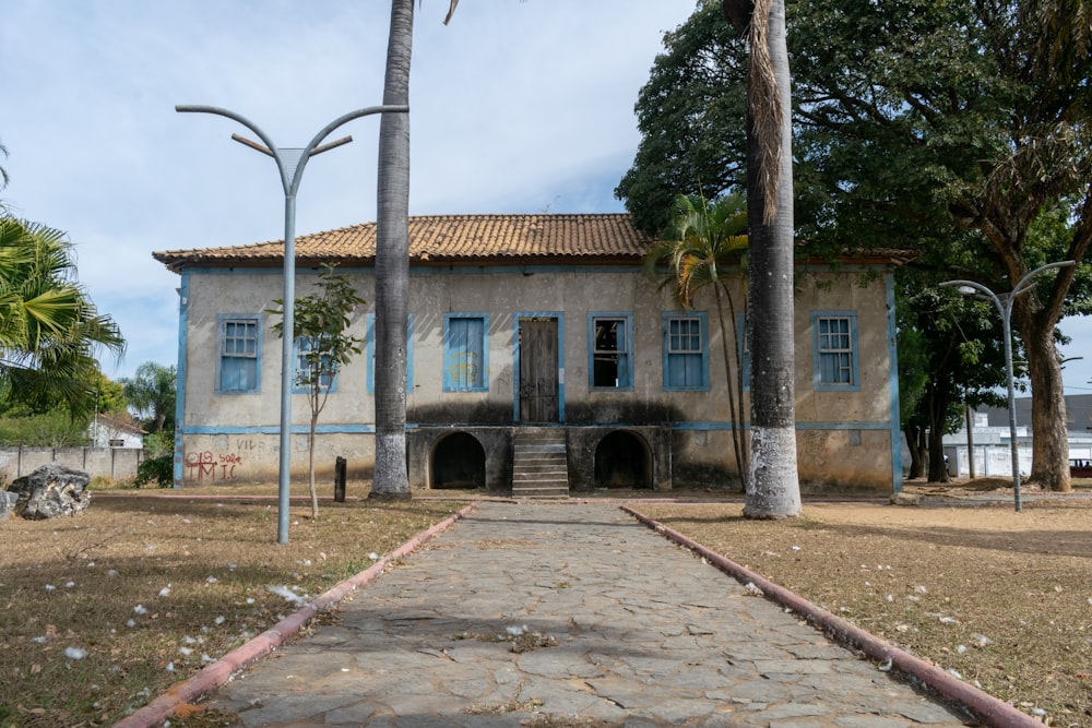 an old building with blue shutters and palm trees