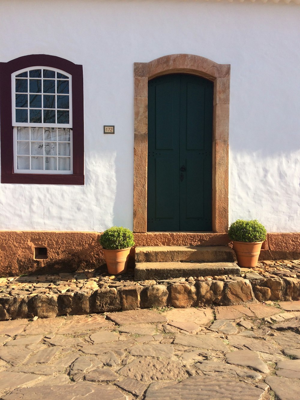 a white house with a green door and window