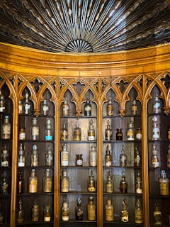 A vintage wooden cabinet filled with delicate porcelain figurines and crystal glassware.