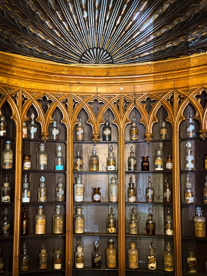 A vintage wooden cabinet filled with delicate porcelain figurines and crystal glassware.