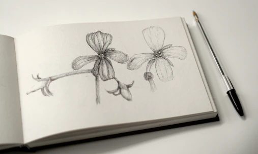 Close-up of a student delicately sketching a floral design with charcoal pencils.
