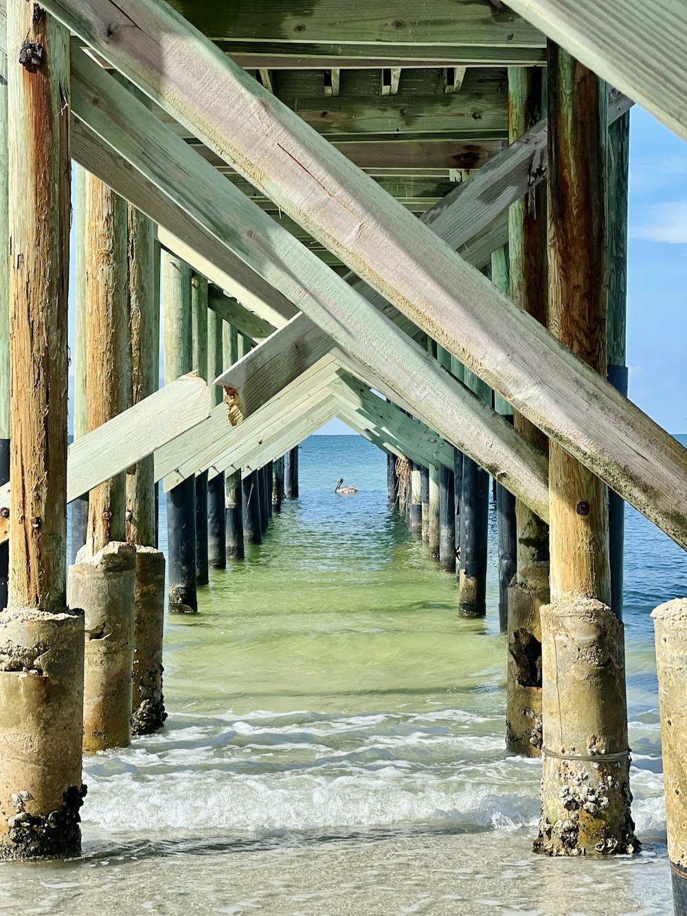 a view of the ocean from under a pier