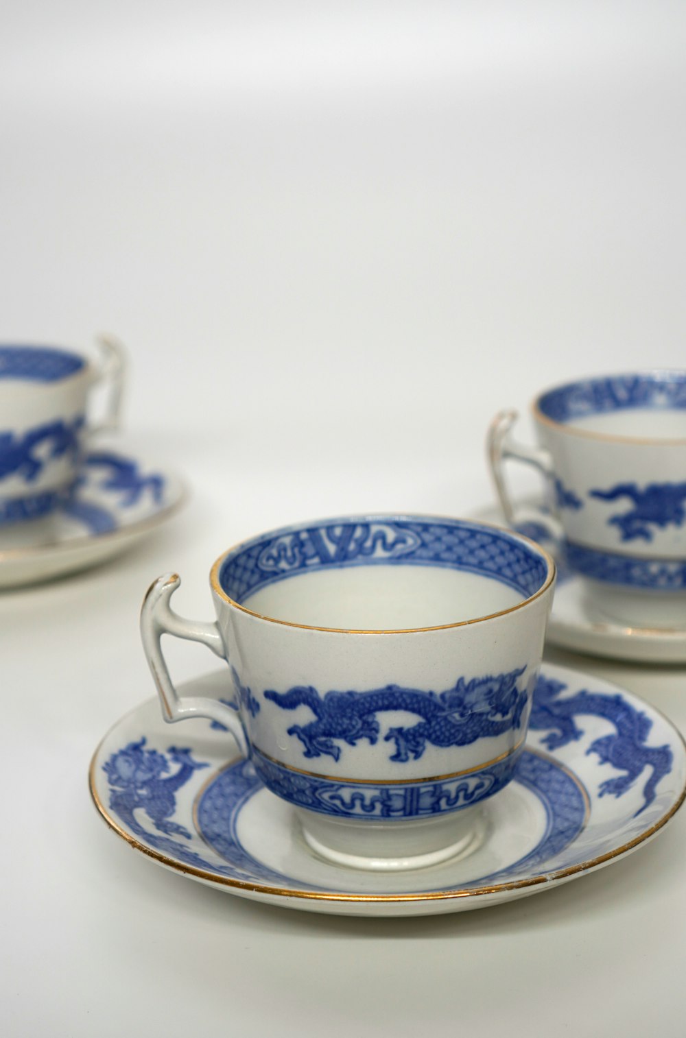 three blue and white cups and saucers