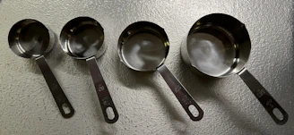 A compact set of measuring cups and spoons neatly stacked beside a mixing bowl.