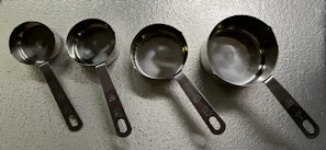 A compact set of measuring cups and spoons neatly stacked beside a mixing bowl.