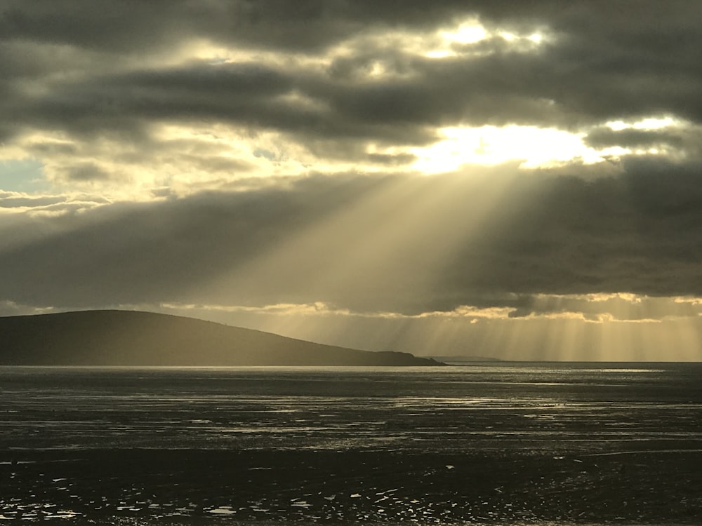 the sun shines through the clouds over the ocean