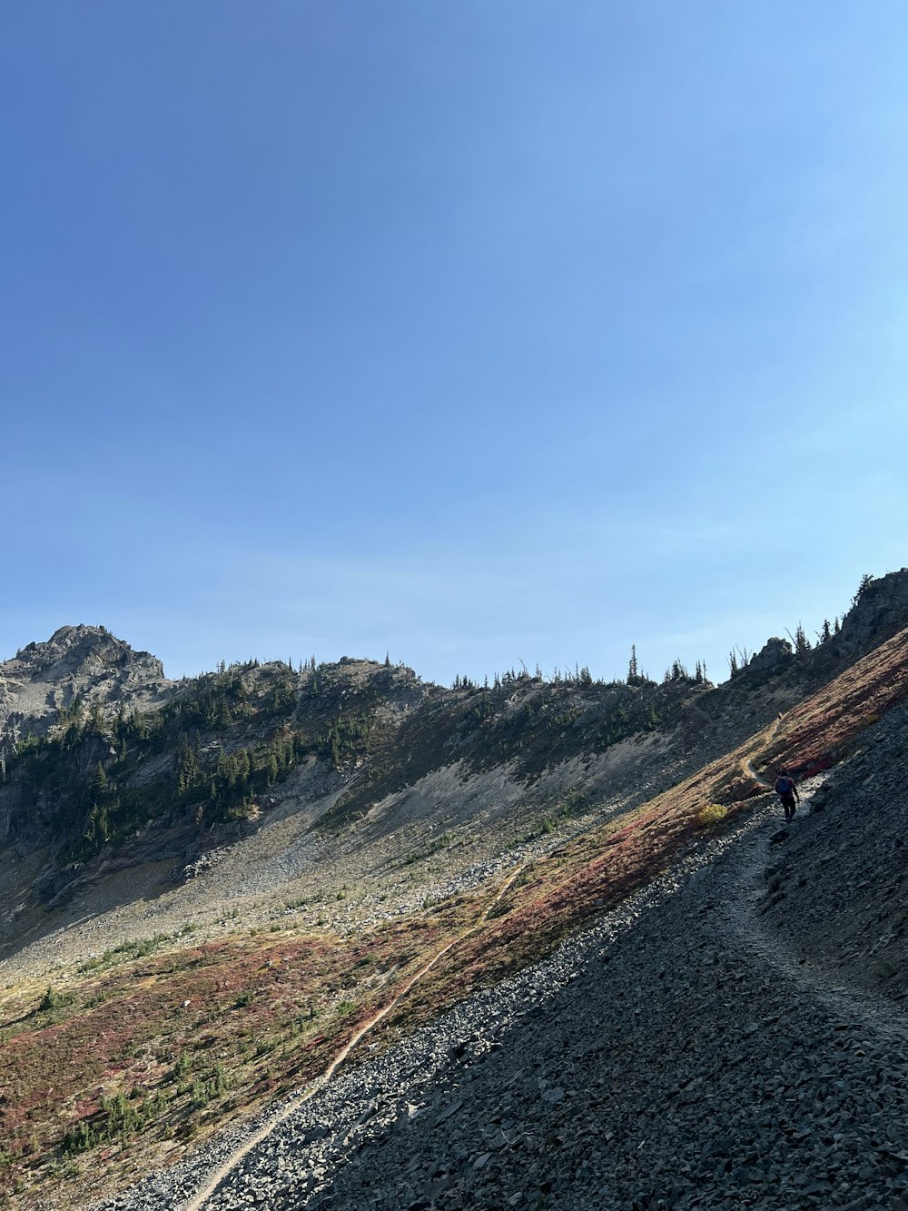 a person riding a bike on a trail in the mountains