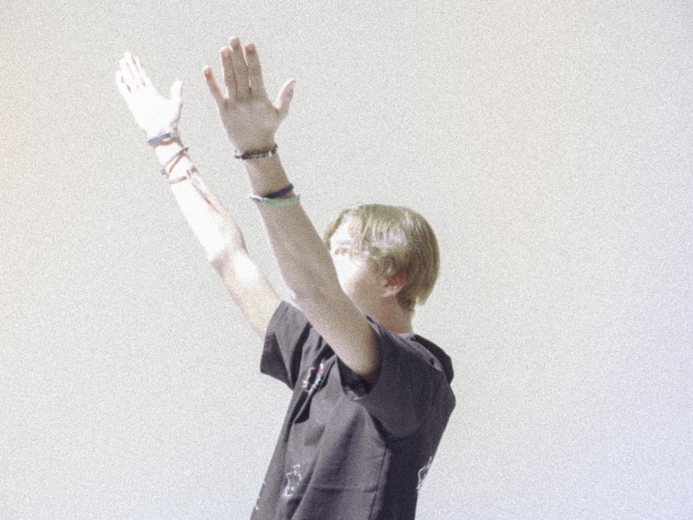 a boy is reaching up to catch a frisbee