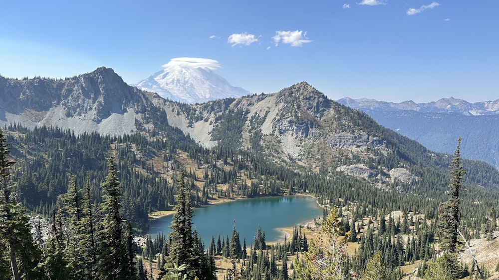 a mountain range with a lake surrounded by trees